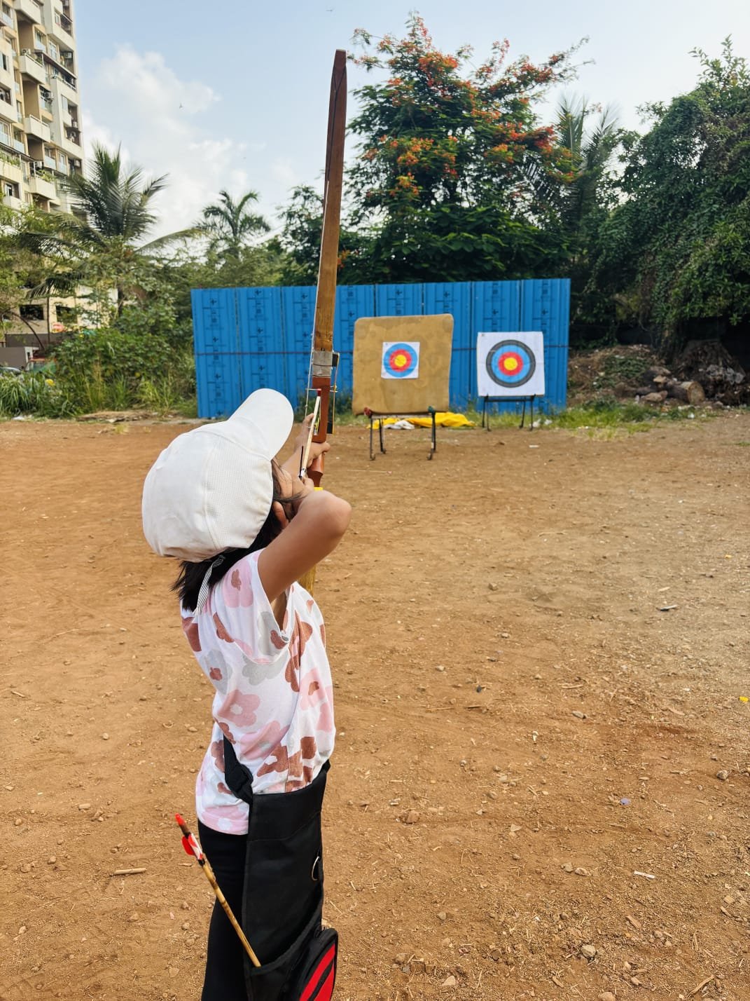 An archer aiming a bow at an outdoor range
